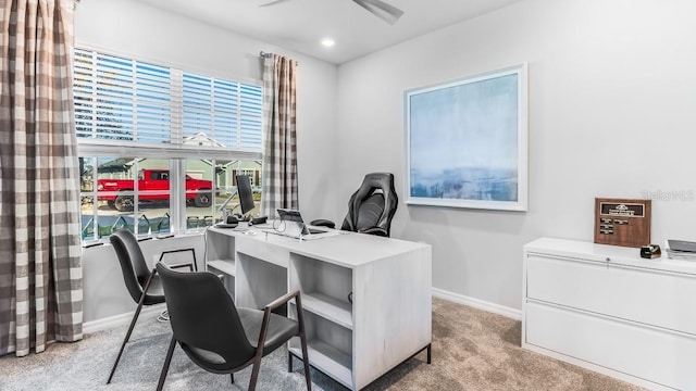 carpeted home office featuring ceiling fan