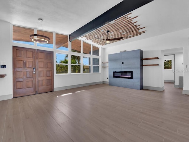 foyer with a wealth of natural light, light hardwood / wood-style flooring, ceiling fan, and beam ceiling