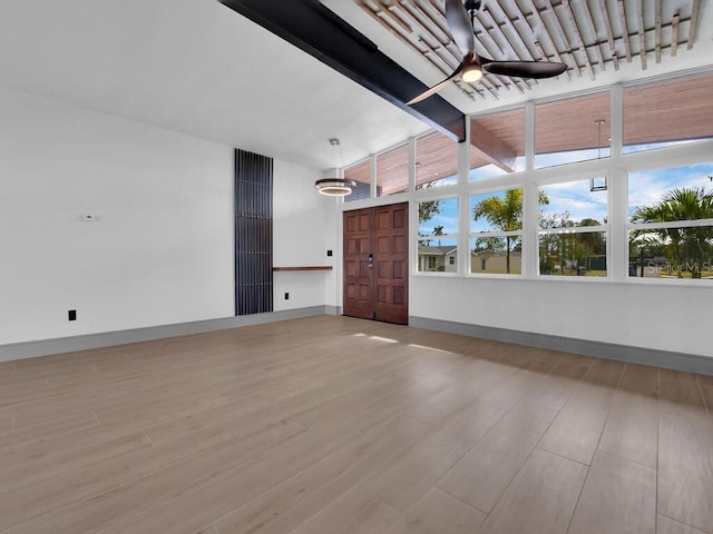 interior space with ceiling fan, beamed ceiling, and wood-type flooring