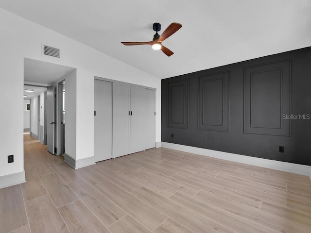 unfurnished bedroom featuring ceiling fan, light hardwood / wood-style flooring, and vaulted ceiling