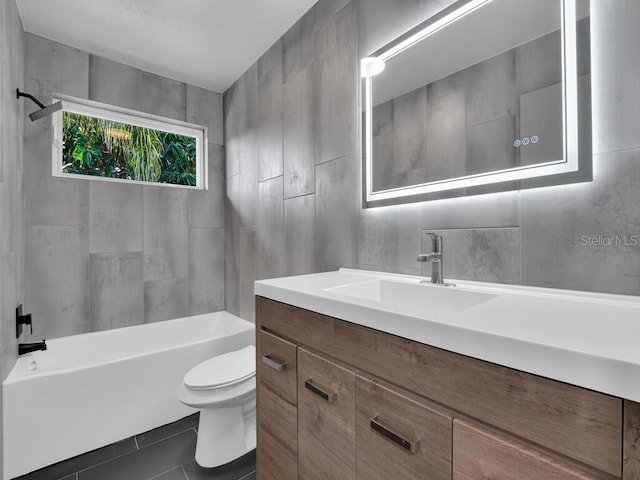 full bathroom featuring tile patterned floors, vanity, tile walls, toilet, and tiled shower / bath