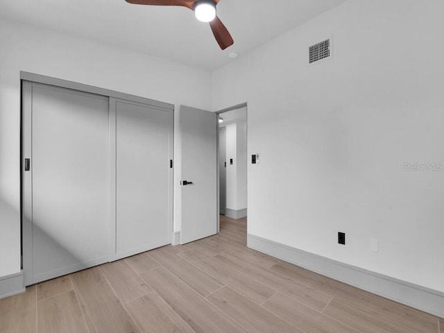 unfurnished bedroom with ceiling fan, a closet, and light hardwood / wood-style floors