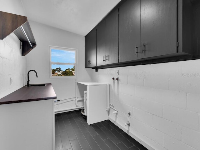 laundry area featuring sink and cabinets