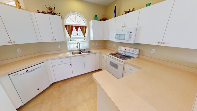 kitchen with kitchen peninsula, white appliances, sink, white cabinets, and light tile patterned flooring