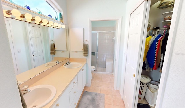 bathroom featuring tile patterned floors, vanity, a shower with shower door, and toilet