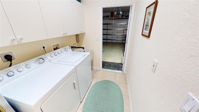 washroom with light tile patterned flooring, cabinets, and separate washer and dryer