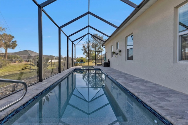 view of pool with glass enclosure and a patio