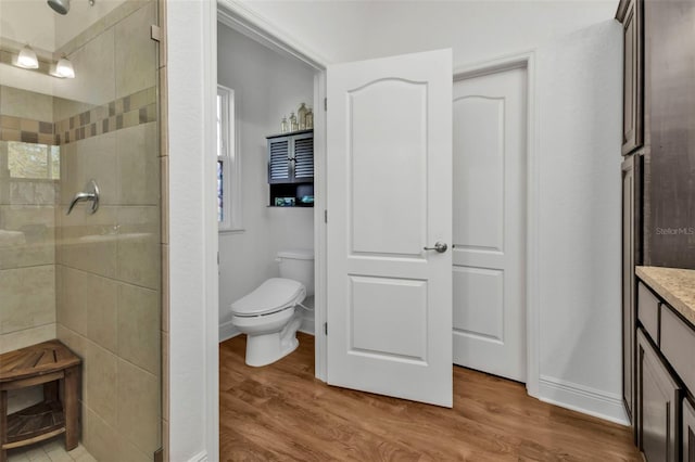 bathroom featuring walk in shower, toilet, vanity, and wood-type flooring