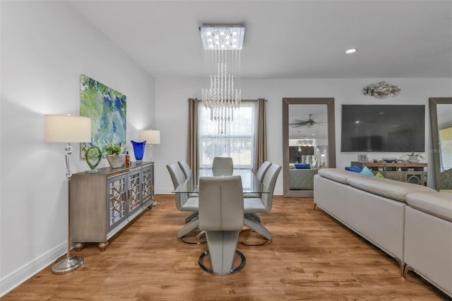 dining space featuring light wood-type flooring and a chandelier