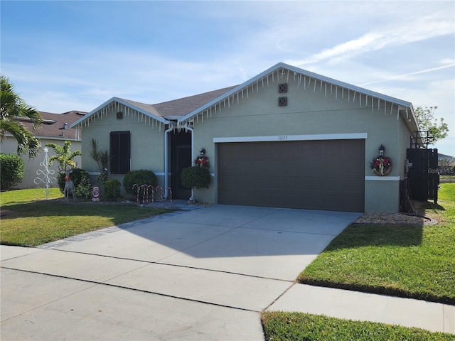 ranch-style house featuring a garage and a front lawn