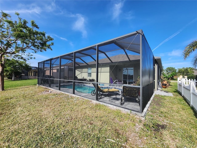 rear view of house with glass enclosure, a fenced in pool, and a yard