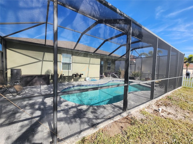 view of pool featuring glass enclosure and a patio area