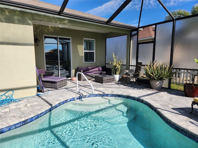 view of pool featuring a patio area, glass enclosure, and an outdoor hangout area