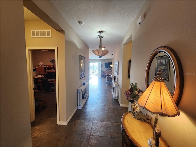 hall with a textured ceiling