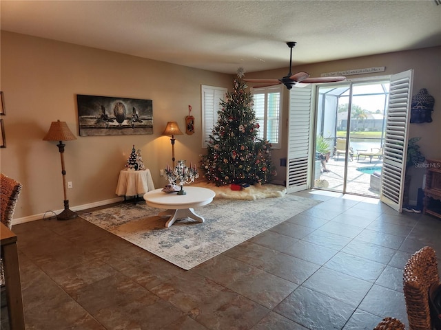 living room featuring a textured ceiling and ceiling fan