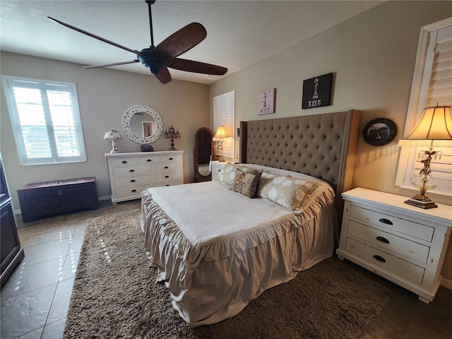 bedroom featuring tile patterned flooring, a textured ceiling, and ceiling fan