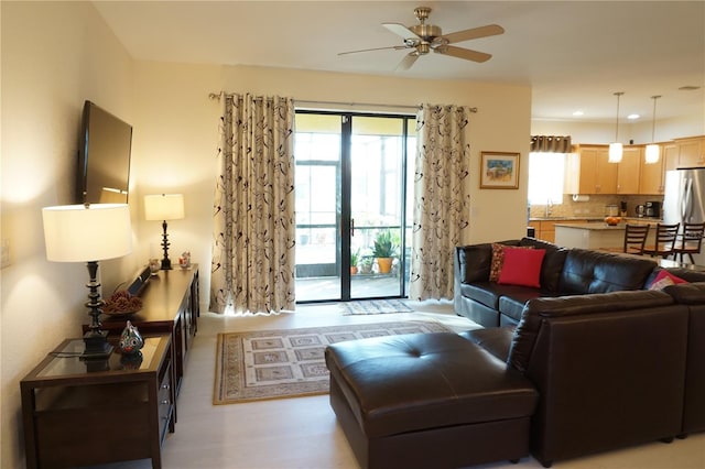 living room with ceiling fan and sink