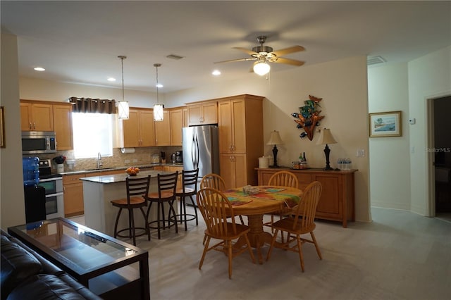 dining space featuring ceiling fan and sink