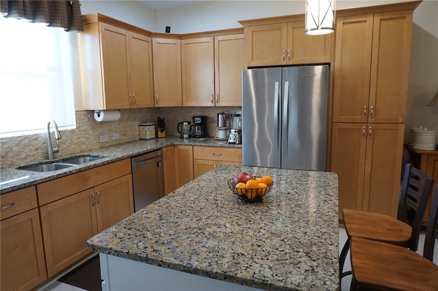 kitchen with backsplash, light stone countertops, sink, and appliances with stainless steel finishes