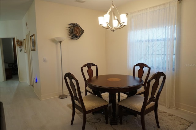 dining area featuring light wood-type flooring and a chandelier