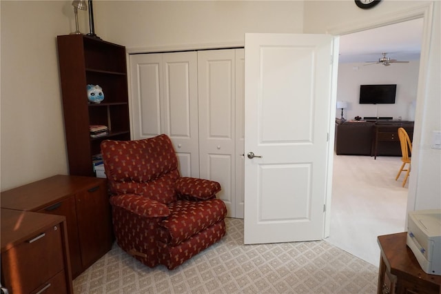 sitting room featuring ceiling fan and light carpet