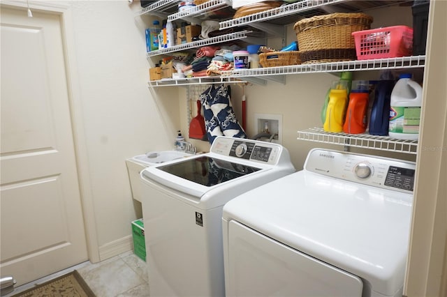 clothes washing area with independent washer and dryer and light tile patterned floors