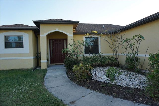 view of exterior entry featuring a yard