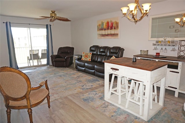 living room featuring wood-type flooring and ceiling fan with notable chandelier