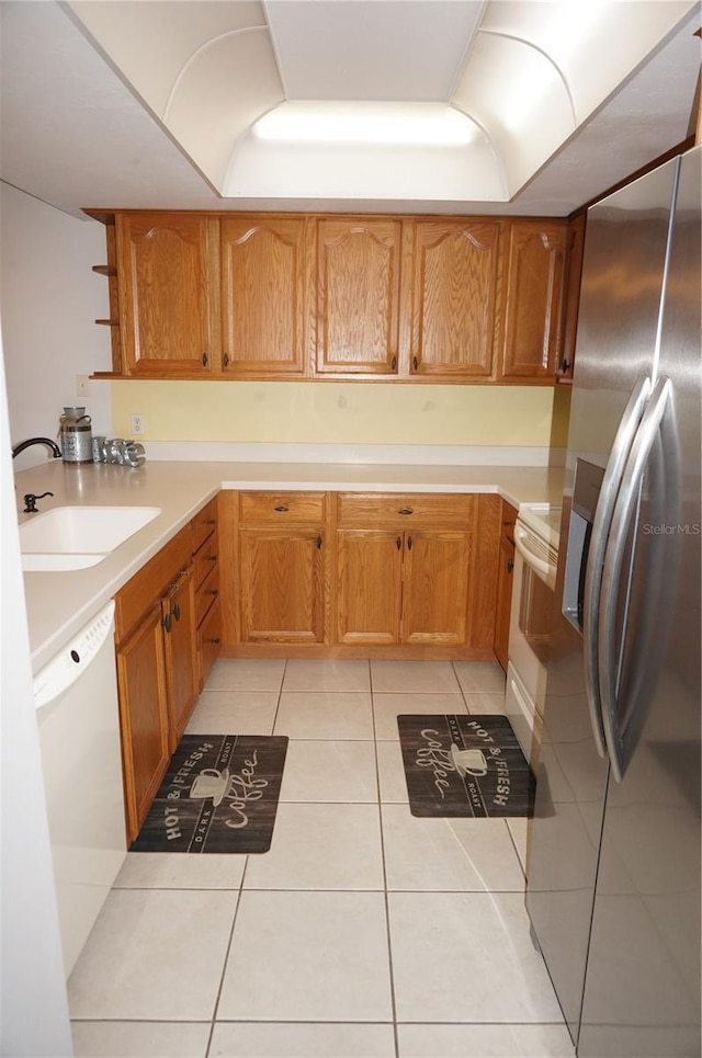 kitchen with exhaust hood, white appliances, sink, and light tile patterned floors