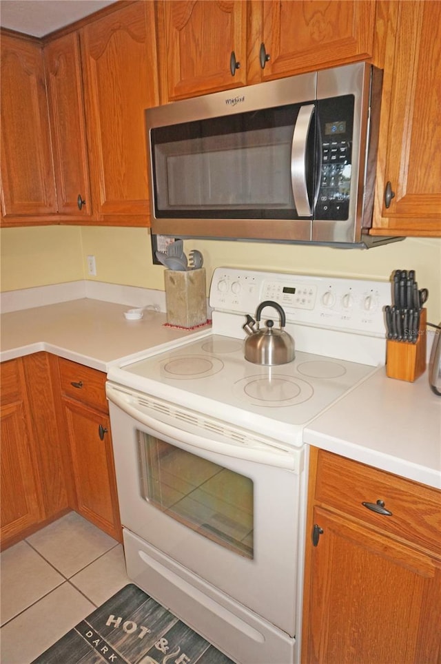 kitchen with light tile patterned floors and white electric stove