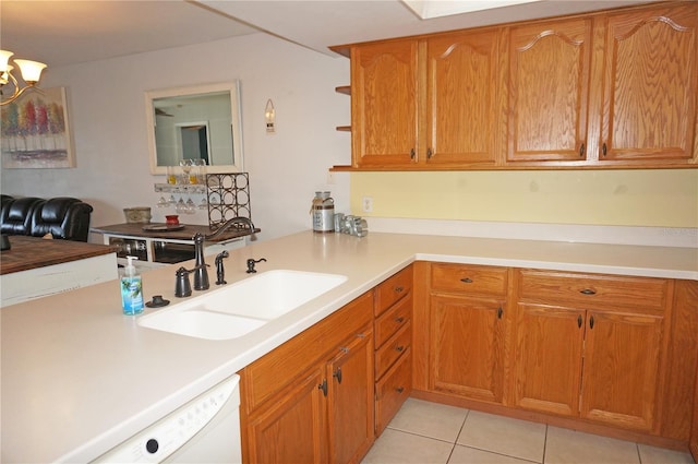 kitchen with light tile patterned flooring, sink, kitchen peninsula, dishwasher, and a notable chandelier