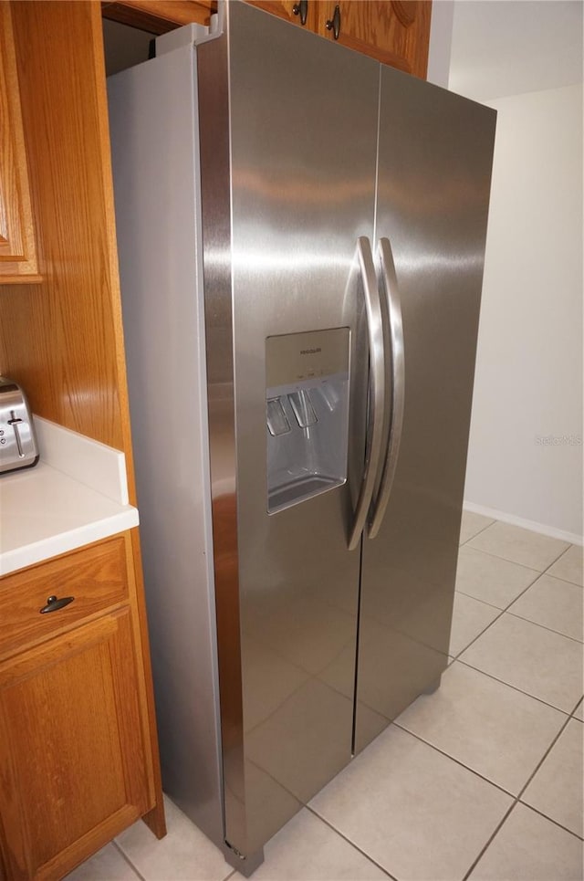 kitchen featuring light tile patterned flooring and stainless steel fridge