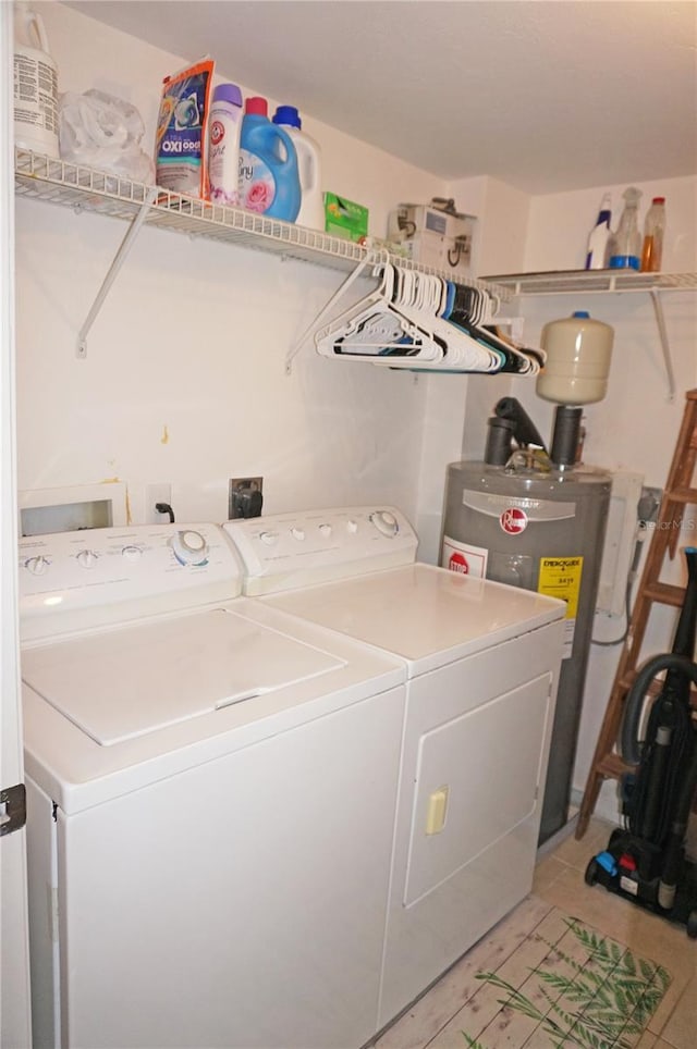 laundry room with electric water heater, light tile patterned floors, and washing machine and clothes dryer