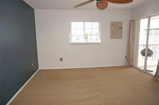 empty room with ceiling fan, light carpet, and a wealth of natural light