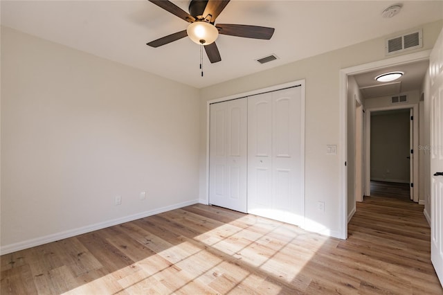 unfurnished bedroom featuring light wood-type flooring, a closet, and ceiling fan