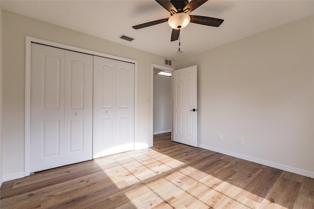 unfurnished bedroom featuring a closet, light hardwood / wood-style flooring, and ceiling fan