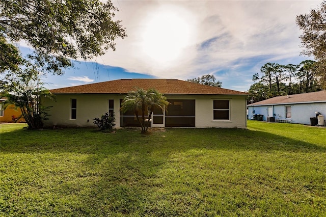 back of house with a lawn and a sunroom