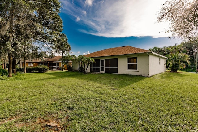 back of house with a lawn and a sunroom