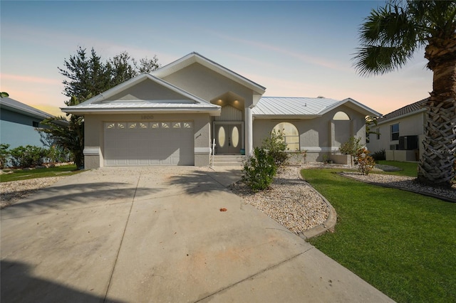 view of front of home with a yard and a garage