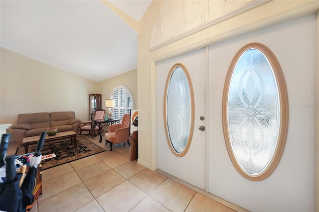 foyer entrance with lofted ceiling and light tile patterned floors