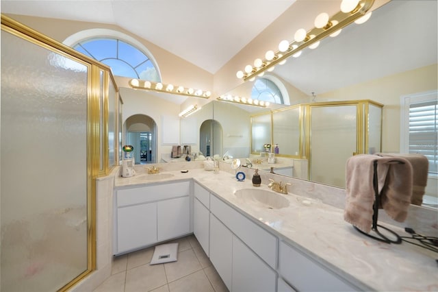 bathroom featuring a wealth of natural light, tile patterned flooring, a shower with shower door, and vaulted ceiling