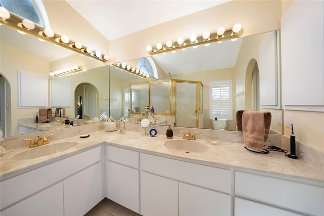 bathroom featuring tile patterned floors, vanity, vaulted ceiling, and walk in shower