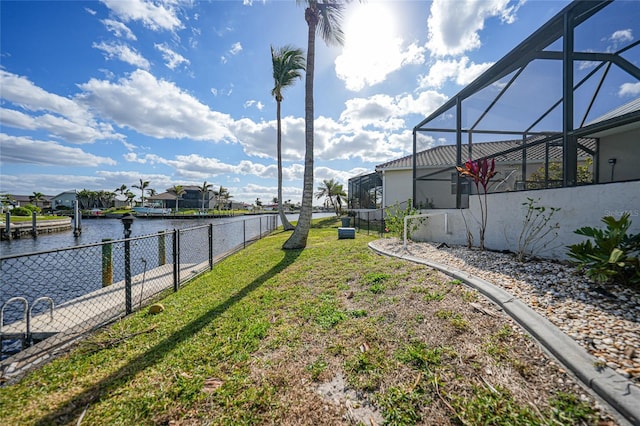 view of yard with a lanai and a water view