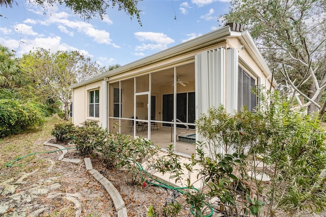 view of side of home featuring a patio area and a sunroom