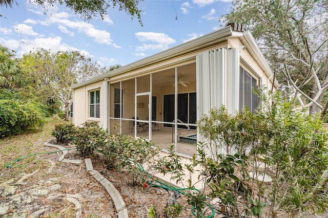 10494 Princess Ct, Punta Gorda, FL 33955 - view of side of home featuring a sunroom, ceiling fan, and a patio area