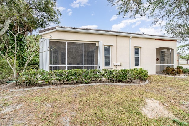 view of home's exterior featuring a yard and a sunroom