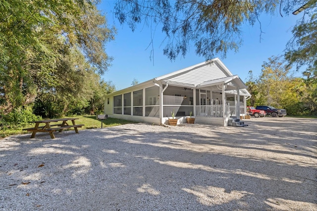 back of property with ceiling fan and a sunroom