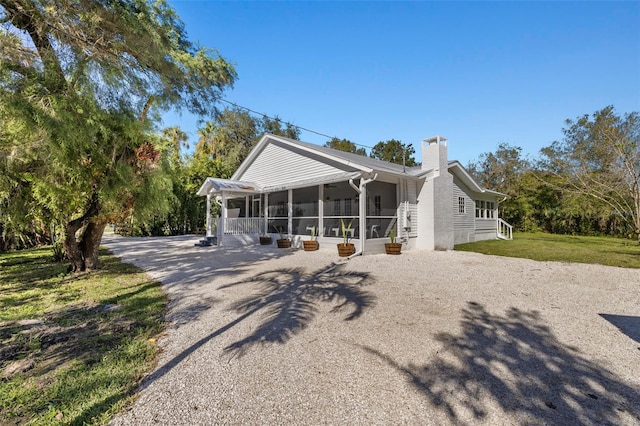 view of front of home featuring a front lawn and a sunroom