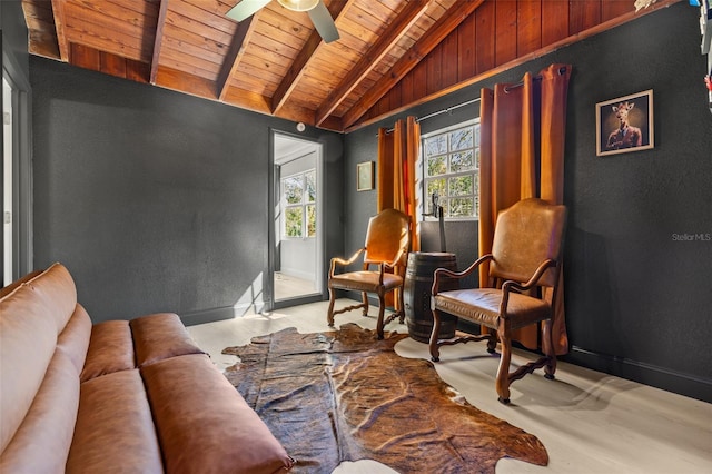 sitting room with vaulted ceiling with beams, ceiling fan, and wood ceiling