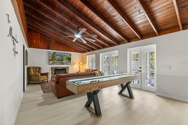 game room featuring french doors, ceiling fan, beamed ceiling, light hardwood / wood-style floors, and wood ceiling